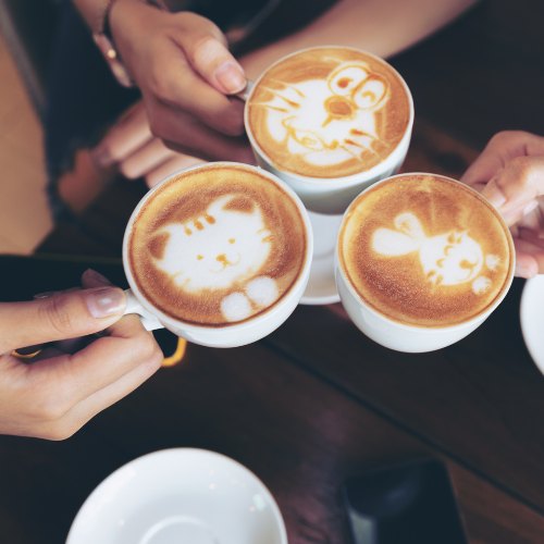 Two cups of coffee and a notebook on a table, ready for a conversation